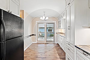 Kitchen with a black refrigerator and white cabinets