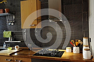 Kitchen with Black Tiles, Natural Wood Worktop, Stove