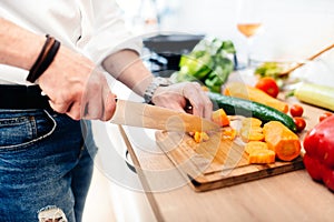 Kitchen chef, master cook preparing dinner. details of knife cutting vegetables in modern kitchen photo