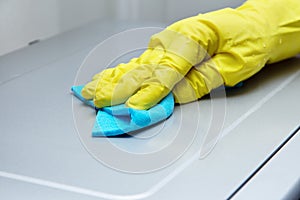 Kitchen cleaning.  female hand in a yellow rubber glove wipes the surface of the microwave oven from dust and dirt