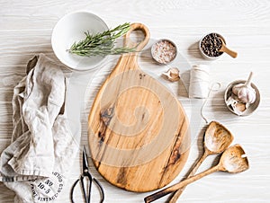 Kitchen cooking flat lay. Various ingredients, kitchen utensils and wood board layout on light background. Top view