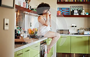 Kitchen counter, woman and drinking coffee in morning for wake up, relax and hot beverage in house. Gen z girl, drink