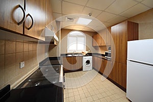 Kitchen with cupboards, washingmachine and fridge