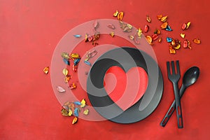 Kitchen cutlery on plate with gift and colorful rose. Happy Valentines Day scene