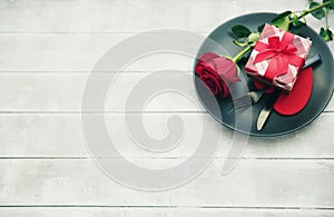 Kitchen cutlery on plate with gift and red rose. Happy Valentines Day