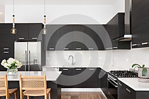 A kitchen with dark wood cabinets and marble countertops.