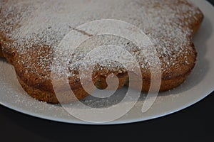 Kitchen, delicious, unusual homemade cake made of banana in the shape of a flower and placed on a white plate.