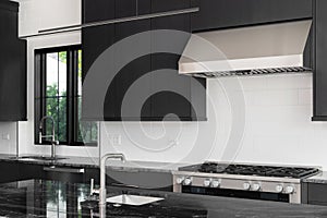 A kitchen detail with dark modern cabinets and black countertop.