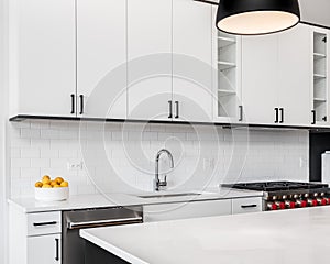 A kitchen detail with white and black cabinets.