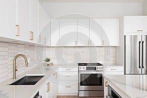 A kitchen detail with white cabinets and a brown picket tile backsplash.