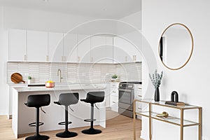 A kitchen detail with white cabinets, picket tile backsplash, and cozy decor.