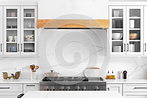 A kitchen detail with white cabinets and a stainless steel stovetop.