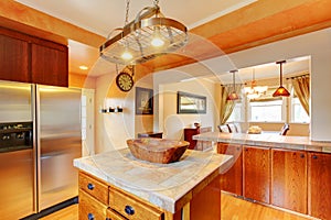 Kitchen and dining room interior with brown wooden cabinets and dining table set.