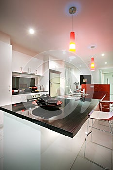 A kitchen with dining table and beautiful red chair