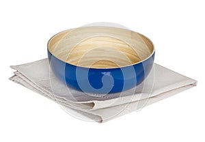 Kitchen dish wooden bowl on a napking isolated.