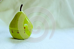 Kitchen egg timer in pear shape turned on 5 minutes isolated on milky background,close up view of kitchen clock for