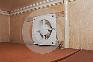 The kitchen exhaust fan after cleaning and washing is installed on the workplace