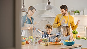 In Kitchen: Family of Four Cooking Together Healthy Dinner, Fool Around and Dance. Mother, Father,