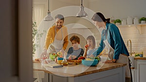 In Kitchen: Family of Four Cooking Together Healthy Dinner. Mother, Father, Little Boy and Girl, P