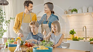 In Kitchen: Family of Four Cooking Together Healthy Dinner. Mother, Father, Little Boy and Girl, P