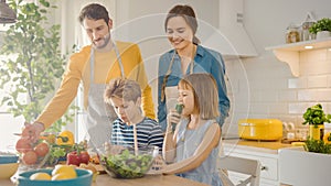 In Kitchen: Family of Four Cooking Together Healthy Dinner. Mother, Father, Little Boy and Girl, P