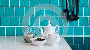 Kitchen features dark gray flat front cabinets paired with white quartz countertops and a glossy blue care tile.