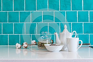 Kitchen features dark gray flat front cabinets paired with white quartz countertops and a glossy blue care tile.