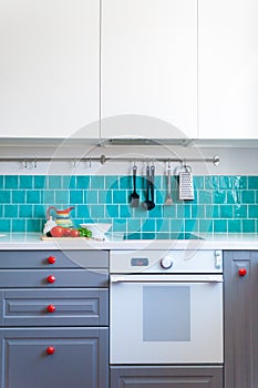 Kitchen features dark gray flat front cabinets paired with white quartz countertops and a glossy blue care tile.