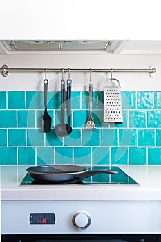 Kitchen features dark gray flat front cabinets paired with white quartz countertops and a glossy blue care tile.