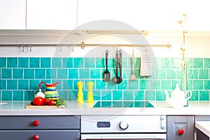 Kitchen features dark gray flat front cabinets paired with white quartz countertops and a glossy blue care tile.