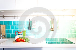 Kitchen features dark gray flat front cabinets paired with white quartz countertops and a glossy blue care tile.