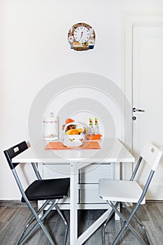Kitchen with Fresh Fruit Basket on the White Table With Chairs