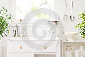 Kitchen furniture beside window with various utensils arranged on shelves