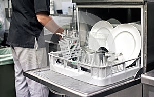 Kitchen hand with an open dishwasher