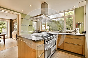 the kitchen has stainless steel appliances and a large window