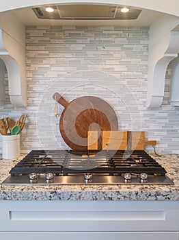 Kitchen home interior with cooktop and chopping boards against tile backsplash