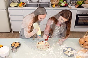 In the kitchen at home, a playful mother and daughter yell while making pizza dough