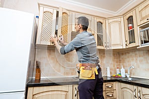 kitchen installation. Worker assembling furniture