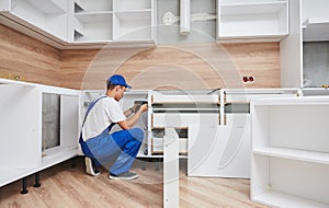 kitchen installation. Worker assembling furniture