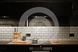 Kitchen interier. black cabinets, white tiles. the pan is on the stove. Scandinavian style kitchen