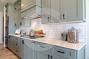 Kitchen interior with cooktop on white counter top under hanging cabinets