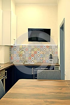 Kitchen interior fragment with flat TV on the wall