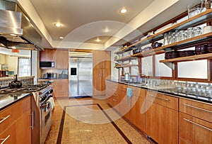 Kitchen interior with long wooden cabinets and shelves.