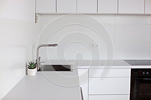Kitchen interior in white color with sink.