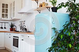 Kitchen interior in white textured colors with blue modern retro fridge and rustic brick wall