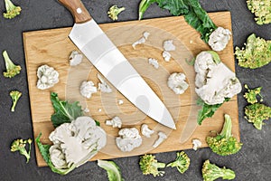 Kitchen knife, fresh cauliflower and broccoli on cutting board