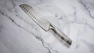 Kitchen knife made of steel on marble table. High angle view