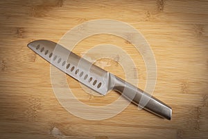 Kitchen knife made of steel on wooden table. High angle view