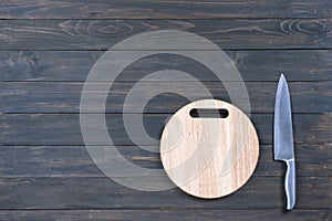 Kitchen knife and wooden round empty cutting board