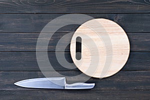 Kitchen knife and wooden round empty cutting board
